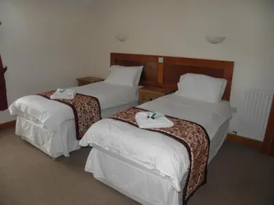 two beds in a hotel room with towels on them at DAIRY MAIDS COTTAGE in Seascale