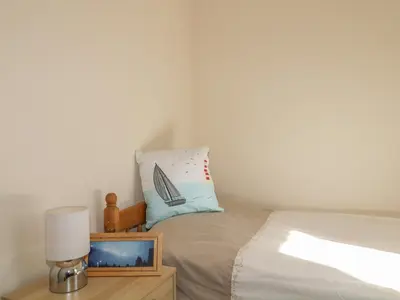 a bedroom with a bed with a pillow and a lamp at Rowan Cottage in St Bees