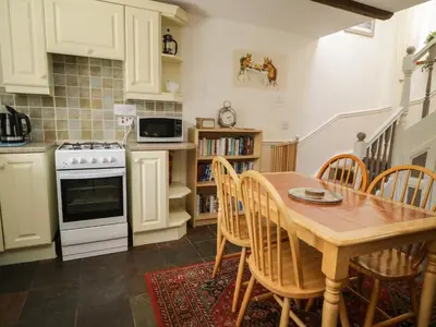 a kitchen with a table and chairs and a stove at Mousehole Cottage in Carlisle
