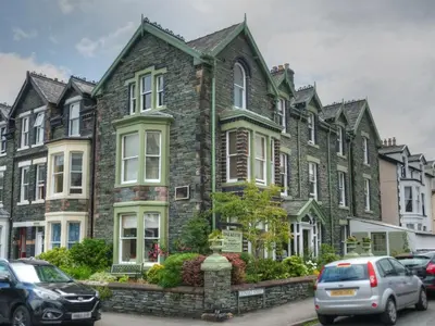 a large brick house with cars parked in front of it at Dalkeith Guest House in Keswick