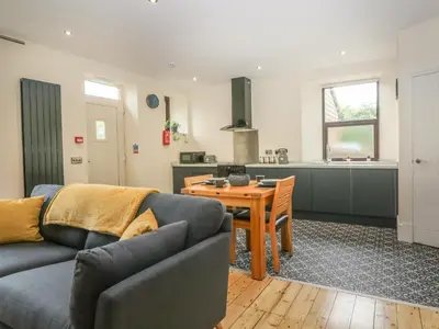 a living room with a couch and a table and a kitchen at Hillcrest in Newton Stewart