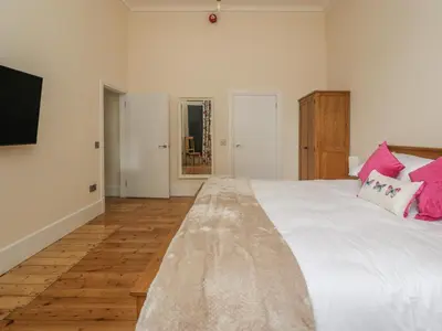 a bedroom with a large white bed with pink pillows at Hillcrest in Newton Stewart