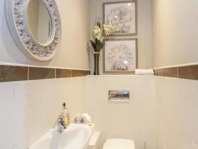 a bathroom with a sink and a toilet and a mirror at Duplex in Moffat