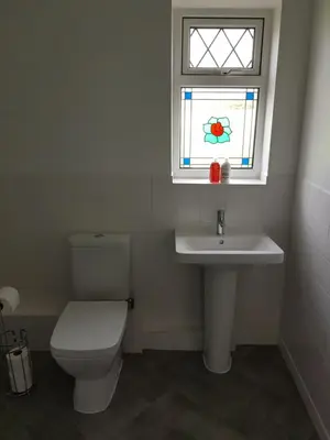 a bathroom with a toilet and a sink and a window at Cleughfoot House in Moffat