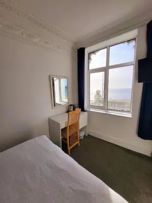 a bedroom with a bed and a desk and a window at At Caledonia in Douglas