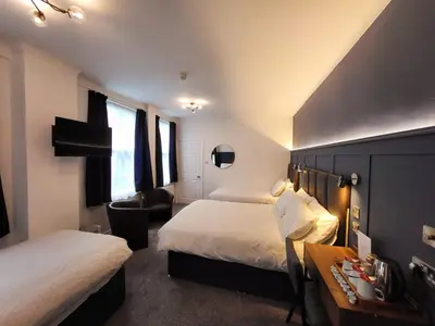 a hotel room with two beds and a desk at At Caledonia in Douglas