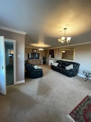 a living room with two couches and a table at Carminnows Holiday Cottage in Carsphairn