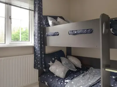 a bunk bed with pillows in a room with a window at West Fells Cottage in Arlecdon
