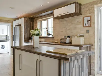 a kitchen with white cabinets and a counter top at West Fells Cottage in Arlecdon