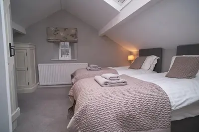 a bedroom with two beds with towels on them at Bakers Rest ideal for 2 families centrally located in Grasmere with walks from the door in Grasmere
