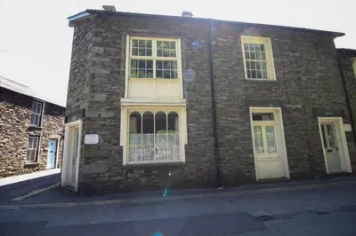 a brick building with white windows on a street at Bakers Rest ideal for 2 families centrally located in Grasmere with walks from the door in Grasmere