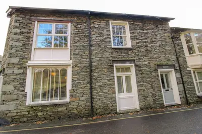 a stone house with white windows and doors at Bakers Rest ideal for 2 families centrally located in Grasmere with walks from the door in Grasmere