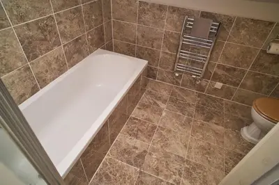a bathroom with a tub and a toilet at Bakers Rest ideal for 2 families centrally located in Grasmere with walks from the door in Grasmere