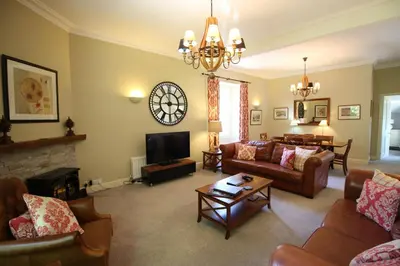 a living room with couches and a tv at Bakers Retreat spacious 1st floor apartment centrally located in Grasmere in Ambleside