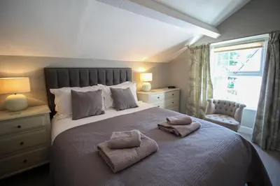 a bedroom with a large bed with two towels on it at Bakers Retreat spacious 1st floor apartment centrally located in Grasmere in Ambleside