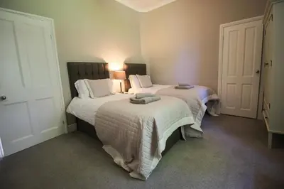 a bedroom with two beds with towels on them at Bakers Retreat spacious 1st floor apartment centrally located in Grasmere in Ambleside