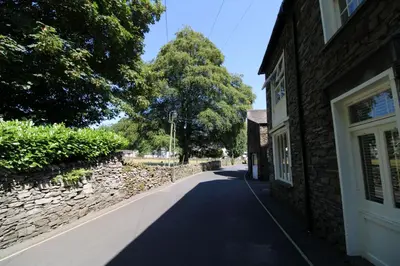 a street next to a building and a stone wall at Bakers Retreat spacious 1st floor apartment centrally located in Grasmere in Ambleside