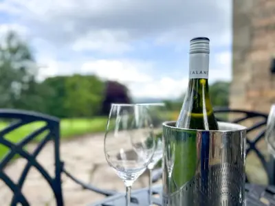 a bottle of wine in a bucket next to a wine glass at Geltsdale Garden Apartment ground floor home in Wetheral close to Carlisle & Ullswater in Wetheral