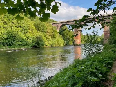 a bridge over a river next to a river at Geltsdale Garden Apartment ground floor home in Wetheral close to Carlisle & Ullswater in Wetheral