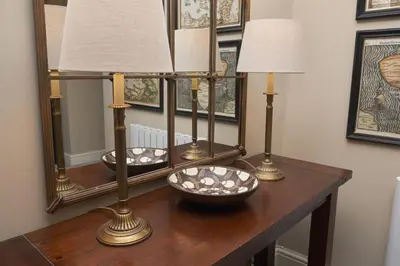 a table with two mirrors and two lamps on it at Old Bakers Cottage ground floor apartment centrally located in Grasmere with patio area in Grasmere