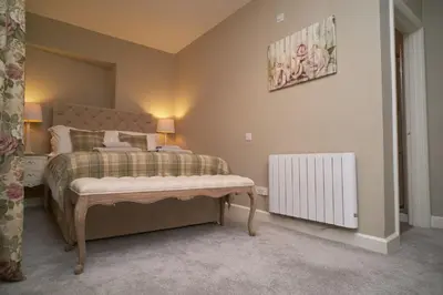 a bedroom with a bed and a radiator at Old Bakers Cottage ground floor apartment centrally located in Grasmere with patio area in Grasmere