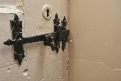a door with a metal latch on a wall at Old Bakers Cottage ground floor apartment centrally located in Grasmere with patio area in Grasmere