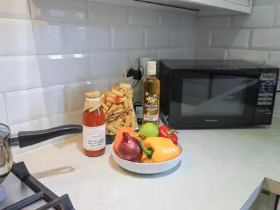 a bowl of fruit on a counter next to a microwave at Fairfell in Keswick