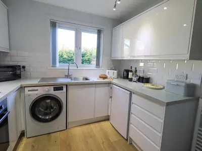 a kitchen with a washing machine and a sink at Fairfell in Keswick