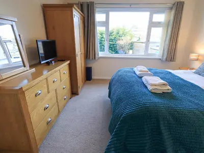 a bedroom with a bed and a dresser with a television at Fairfell in Keswick