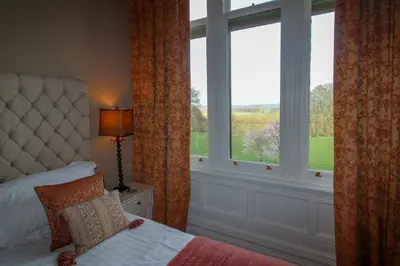 a bedroom with a bed and a large window at Geltsdale East Wing sleeps 6 with River Eden views near Carlisle & Ullswater in Wetheral