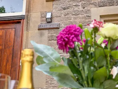 a vase of flowers in front of a building at Geltsdale East Wing sleeps 6 with River Eden views near Carlisle & Ullswater in Wetheral