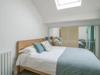 a bedroom with a bed with blue pillows on it at Coney Garth Barn in Beckermet