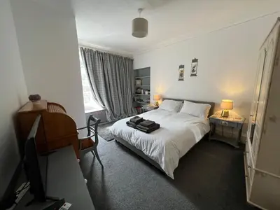 a bedroom with a bed and a desk and a television at Stylish 2nd Floor Georgian Period Flat in Dumfries