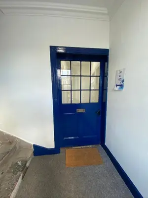 a blue door in the corner of a room at Stylish 2nd Floor Georgian Period Flat in Dumfries