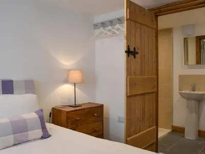 a bedroom with a bed and a sink and a door at Apple Barn in Applethwaite