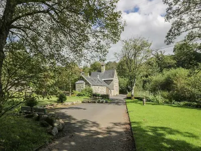 an old house in the middle of a driveway at Cloncaird Castle Estate Cottages in Maybole
