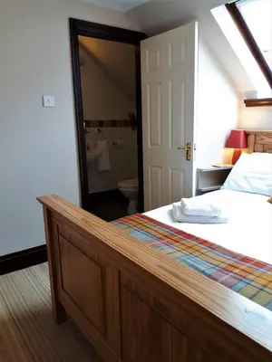 a bedroom with a bed and a large mirror at Corsewall Arms Guest House in Stranraer
