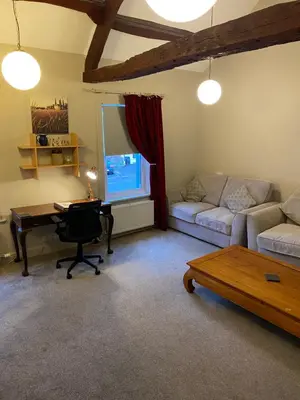 a living room with a couch and a table and a desk at Kezbah 1, 22 the square centre of Dalston village in Dalston