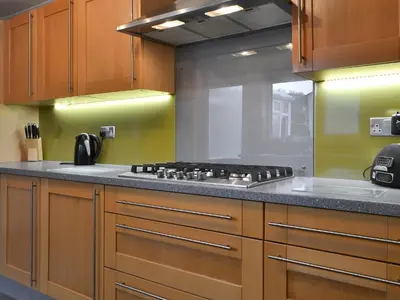 a kitchen with wooden cabinets and a stove top oven at Apple Cross in Keswick