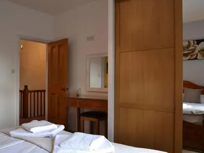 a bedroom with two beds and a sink and a mirror at Rowan House in Threlkeld