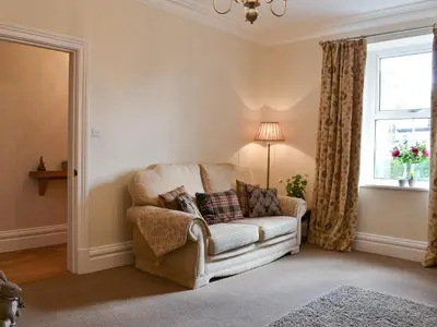 a living room with a chair and a window at Rowan House in Threlkeld