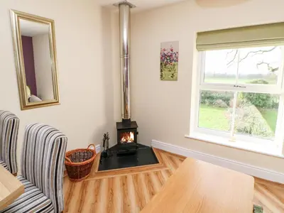 a living room with a wood stove in the corner at Tight Lyne Cottage in Carlisle