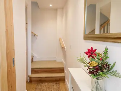 a vase with flowers on a counter in a hallway at Tight Lyne Cottage in Carlisle