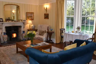 a living room with a blue couch and a table at Applegarth House in Lockerbie