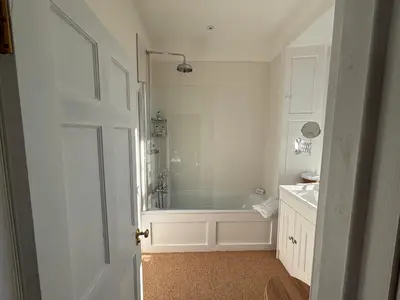 a white bathroom with a tub and a sink at Applegarth House in Lockerbie