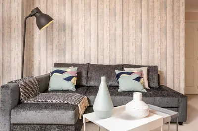 a living room with a couch and a table at The Lucas - Donnini Apartments in Ayr