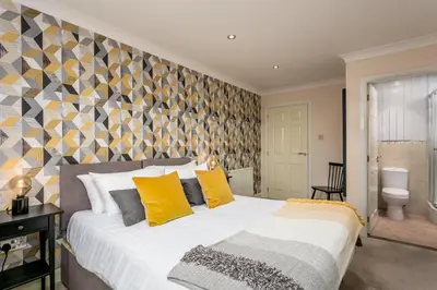 a bedroom with a large bed with yellow pillows at The Lucas - Donnini Apartments in Ayr