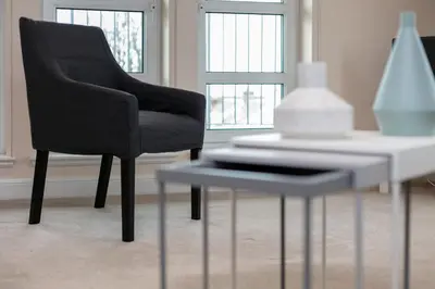 a black chair sitting next to a white table at The Lucas - Donnini Apartments in Ayr