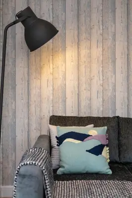 a black lamp sitting next to a couch with a pillow at The Lucas - Donnini Apartments in Ayr