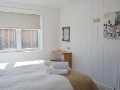 a white bedroom with a bed and a window at Cree Lodge - Uk13636 in Creetown